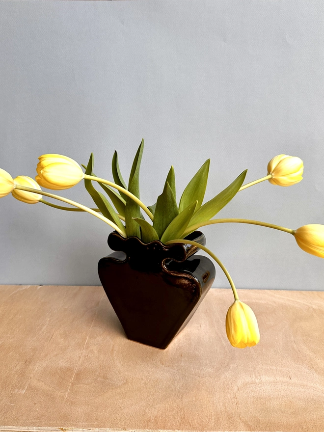 A black vase with tulips