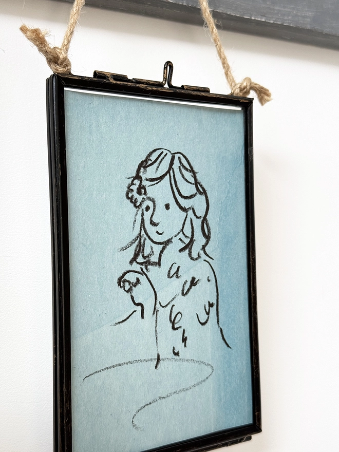 sketchy portrait of girl on blue paper in metal frame