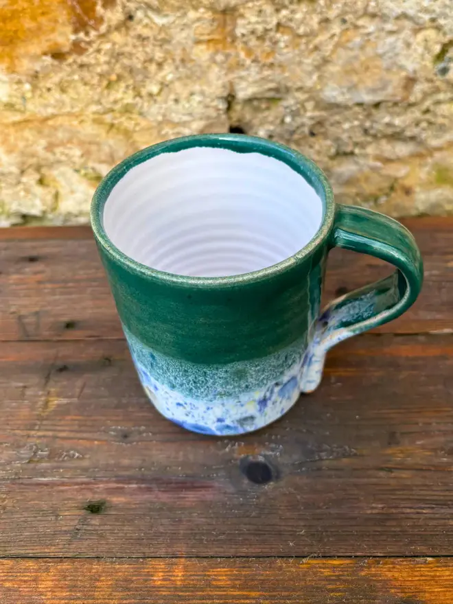 Shoreline Standard Mug, a colourful mug placed on a wooden surface. 
