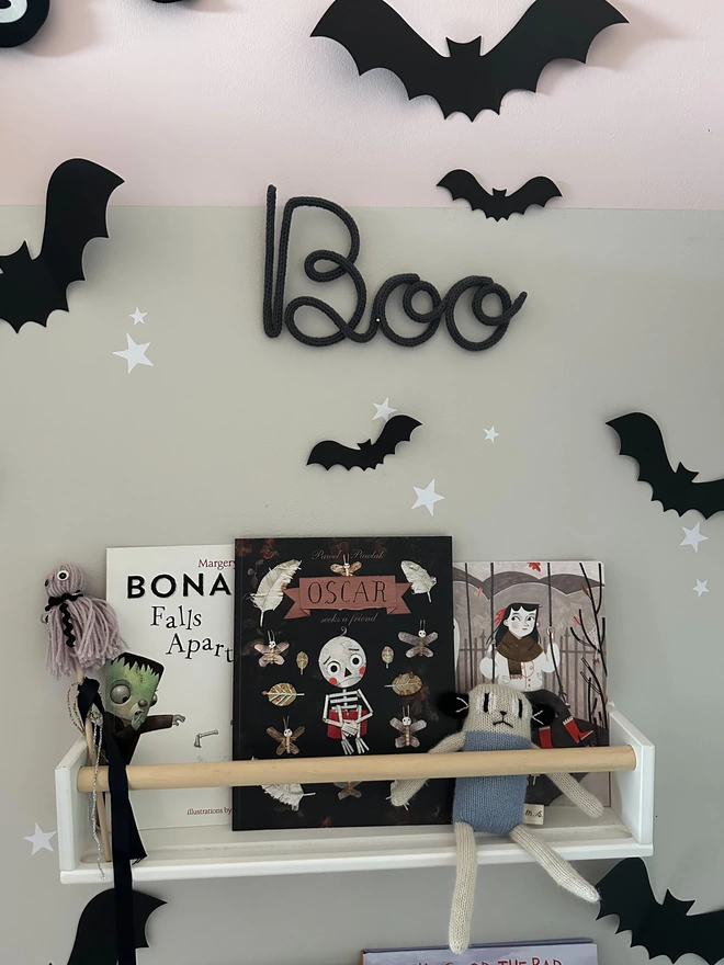 'Boo' knitted wall sign with a capital 'B' hanging alongside kid's halloween decorations.