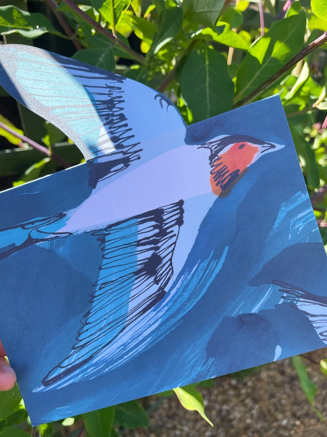 Esther Kent illustrated greeting card showing inky blue swallow illustration on a teal background. The swallow's wing pops u.