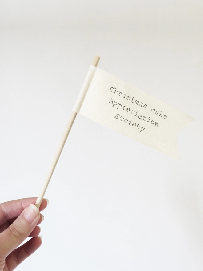 organic cotton flag with hand painted festive message wrapped round wooden dowel.