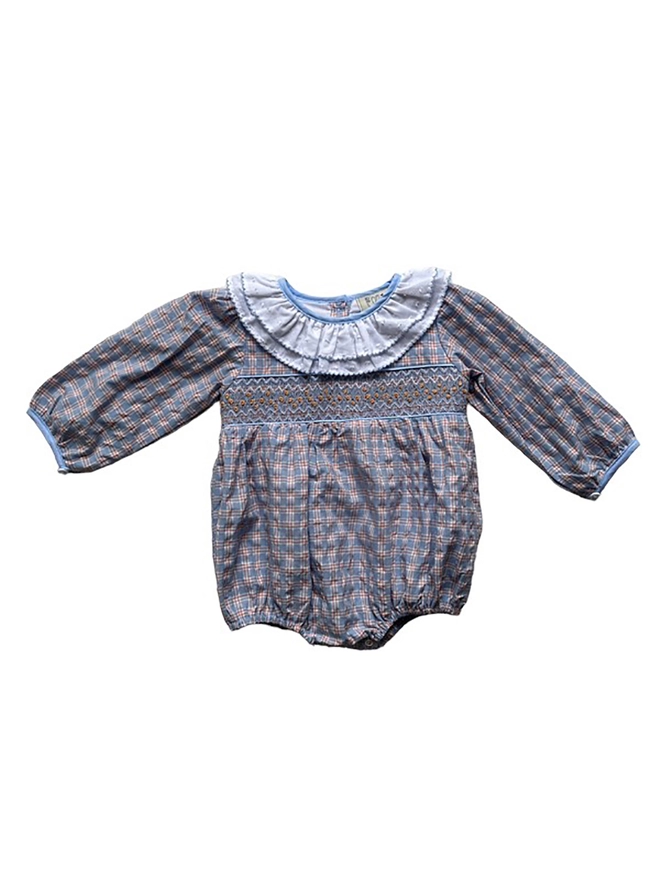 A checked seersucker romper with smocked detailing and a white double frill collar.