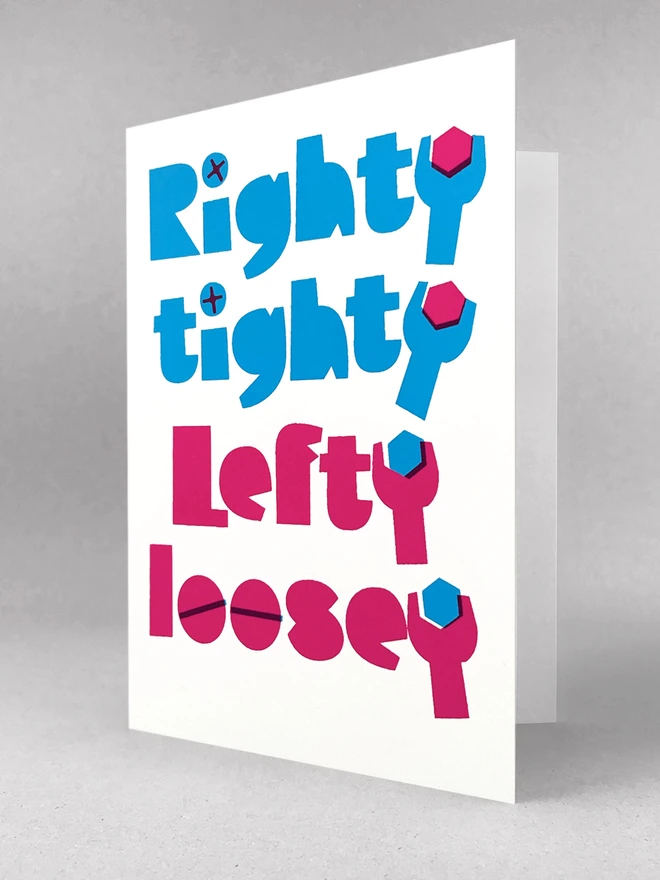 The words Righty tighty screen printed in the colour cyan above the words Lefty loosey printed in magenta. The letter Y at the end of each word is shaped like a spanner. Inside the spanners are hexagon shaped bolts. Overprinted philips screw heads make up the dots of the letter i in righty and tighty and overprinted lines make the o’s in loosey look like standard slot screws. The card is stood at a slightly open at an angle in a light grey studio set.