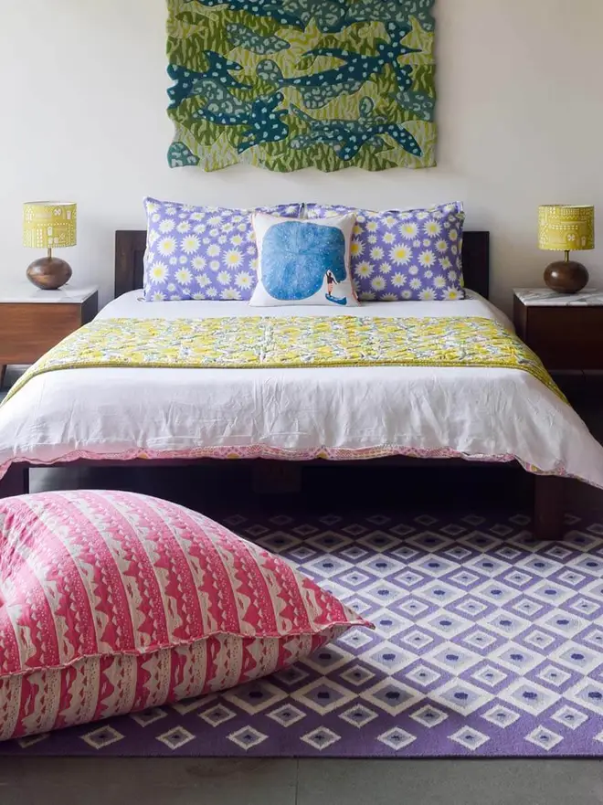 Evil Eye Flatweave Rug, a colourful rug in a living room. It is accompanied by other colourful household items. 