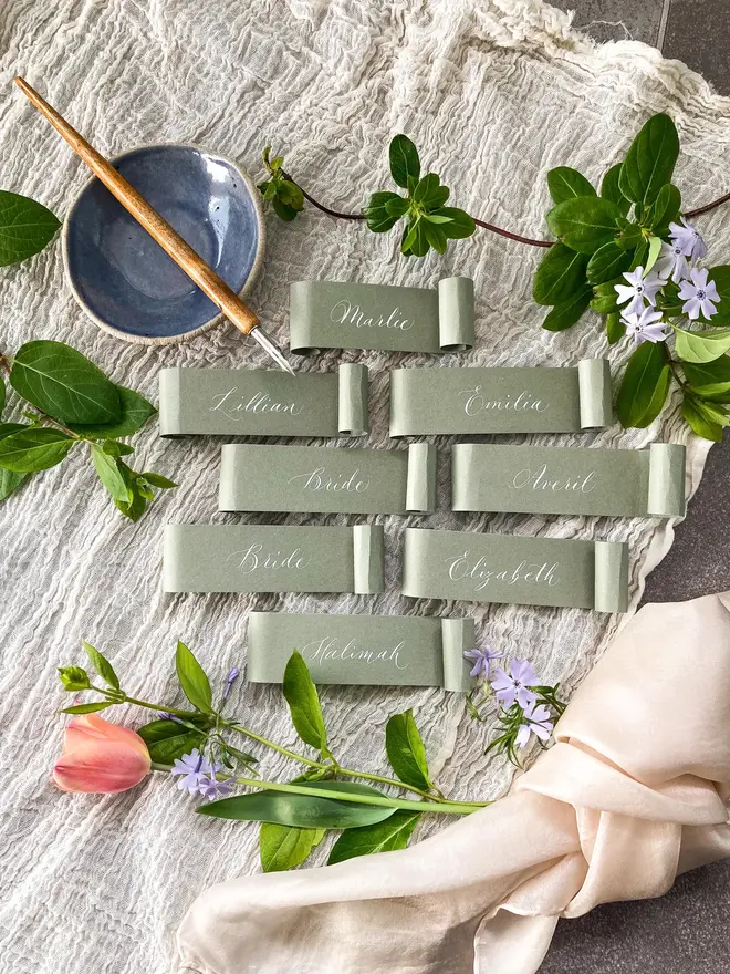 sage green scroll calligraphy wedding place cards. sage green scroll with white calligraphy.