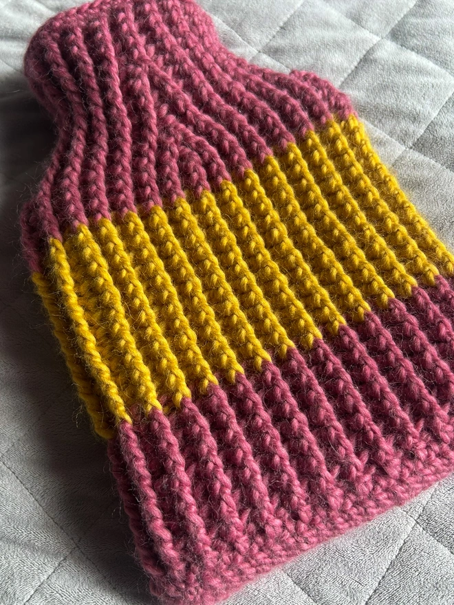 Four hot water bottles in various colour ways