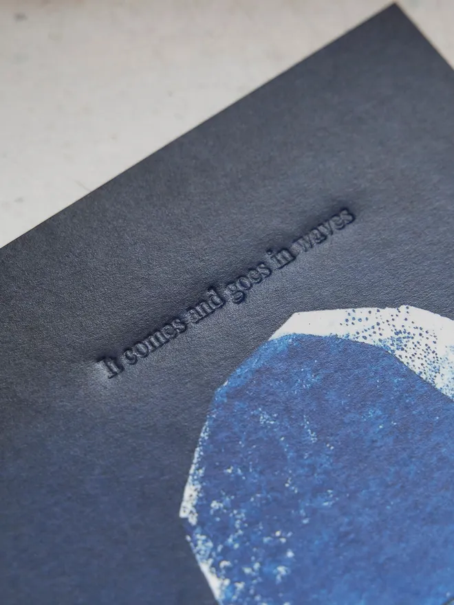 'It comes and goes in waves' artwork - a deep midnight blue with the moon and embossed text, against a grey locker background