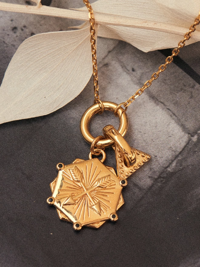 gold necklace with pendant and charm