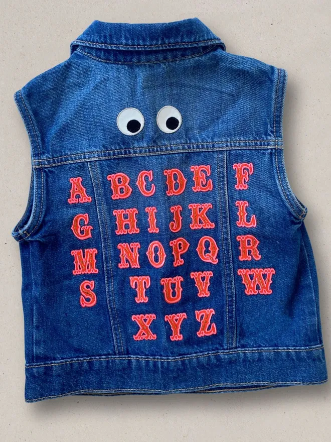Alphabet letter embroidered iron on fabric patches in red and flouro pink.