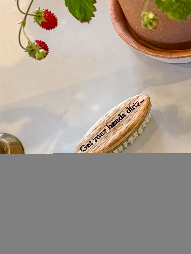 Oak-backed nail brush engraved Get your hands dirty, styled with wild strawberries and a terracotta pot