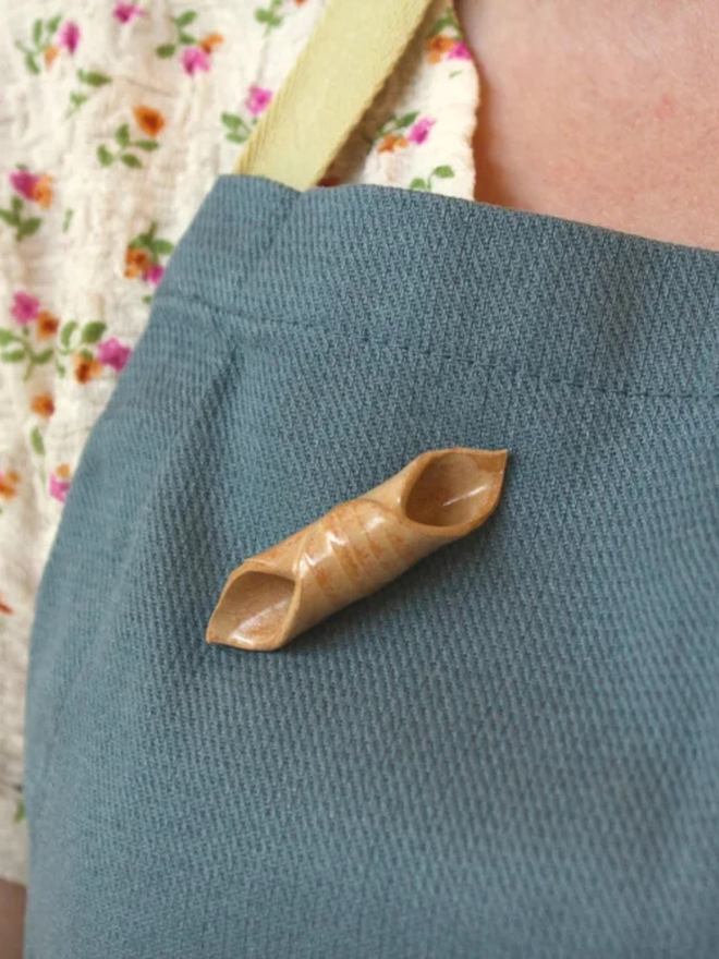 ceramic pasta pin badges. a ceramic garganelli badge photographed on an apron.