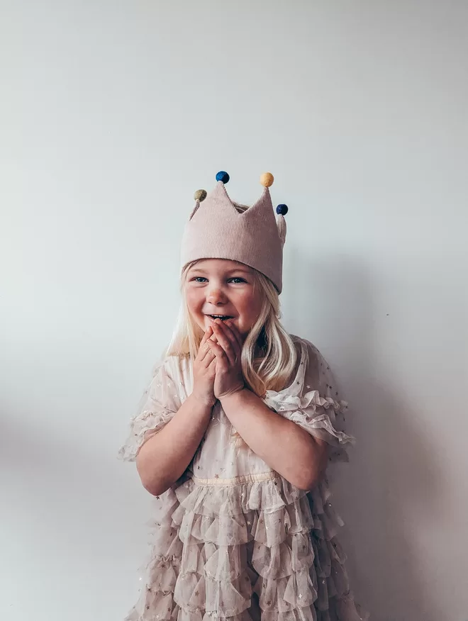 Girl wearing crown with pom poms