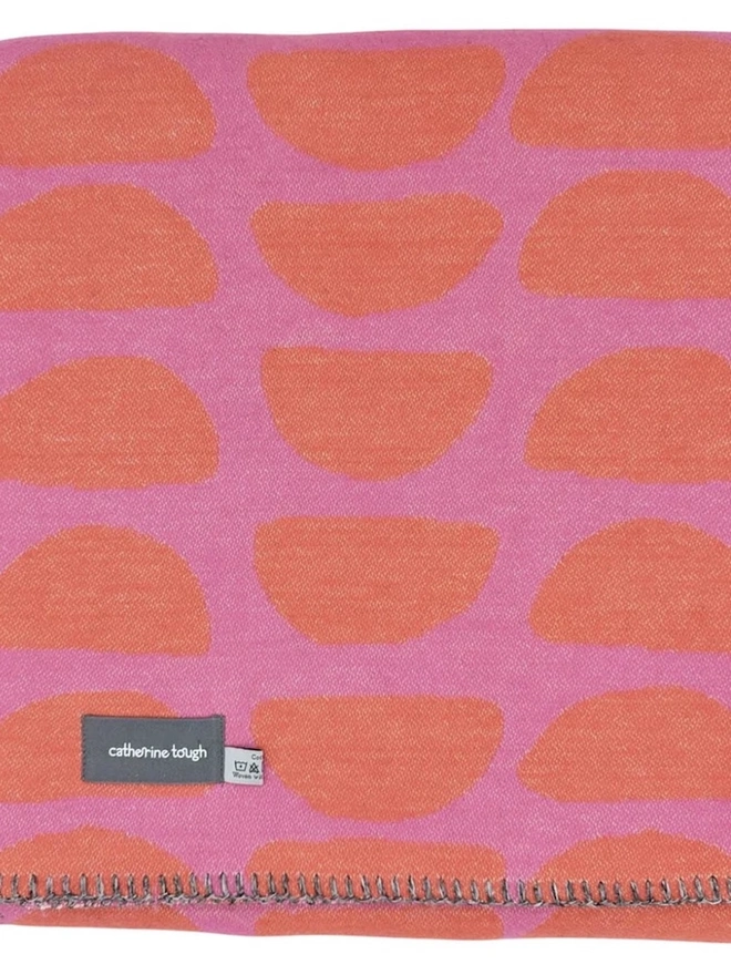 Organic Cotton Throw, a cotton throw folded into a square on a floor. 