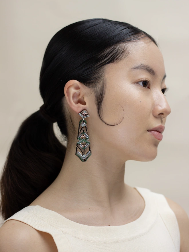 laser cut earrings on model in front of neutral background