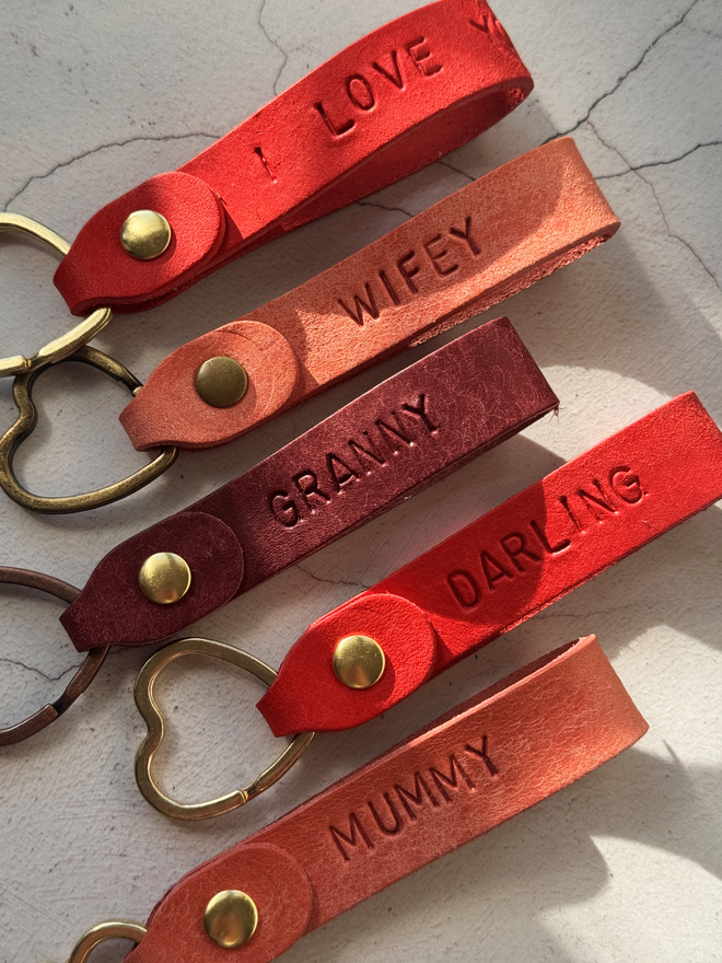 Leather keyring for her, various pink and red keyrings with a heart ring one a white background