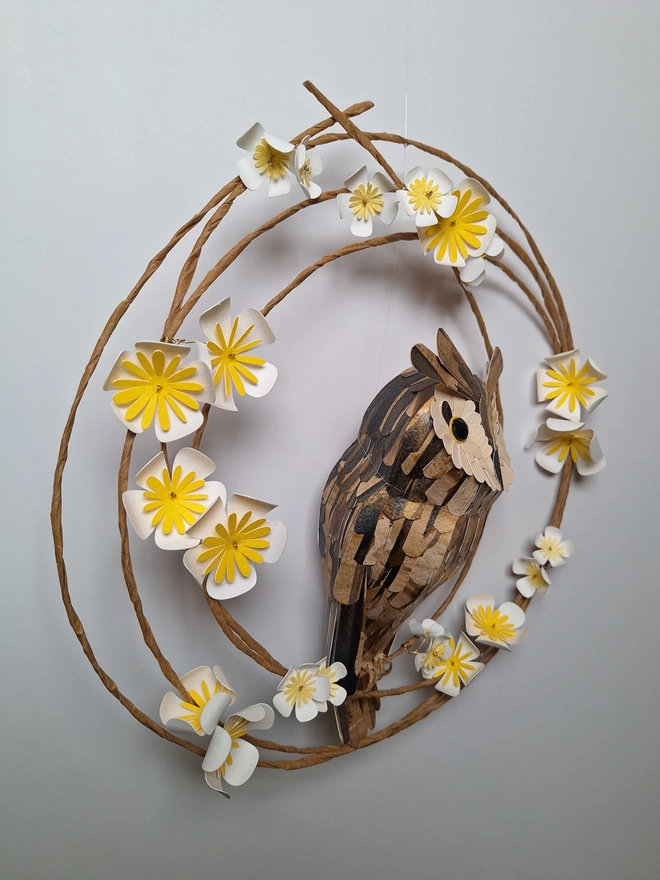 side view of a handmade paper sculpture of a long eared owl