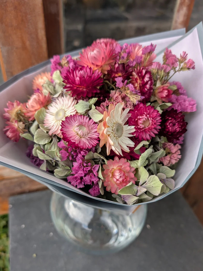 pink petals dried flower bouquet. bouquet of pink dried flowers in a round glass vase.