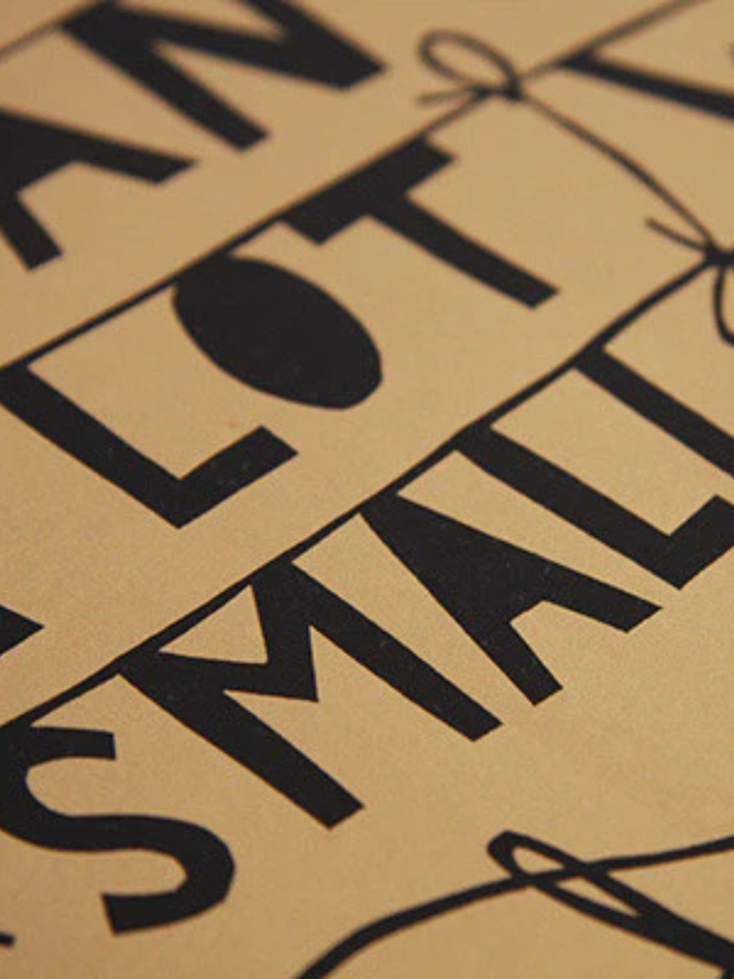 A screenprint with a brown background and black detail, bearing the message 'you can still do a lot with a small brain'. Photograph close up of black lettering.