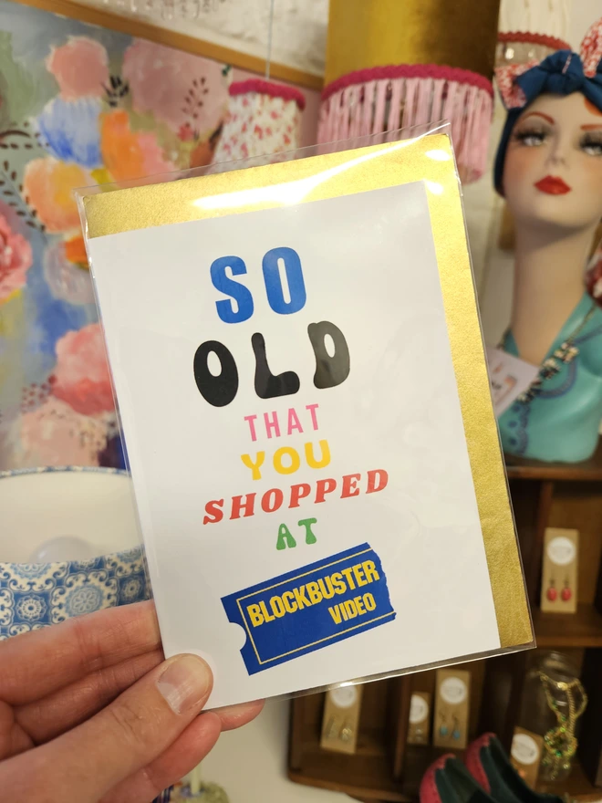 A photograph of the front of a humorous A6 greeting card illustrated using brightly coloured text and the retro shop logo. The text says so old you shopped at Blockbuster