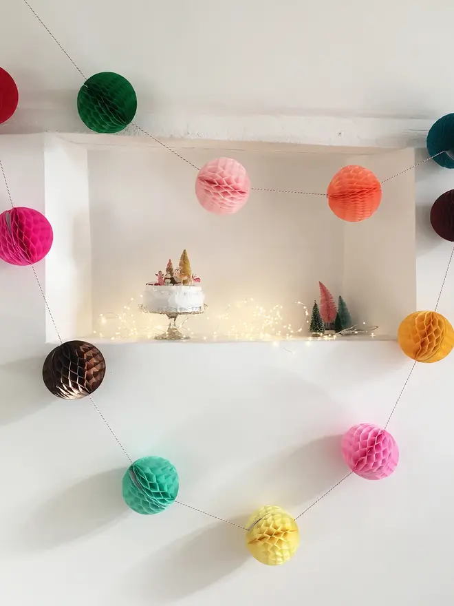 colourful paper ball garland. a string garland with paper balls in assorted colours hanging indoors. 
