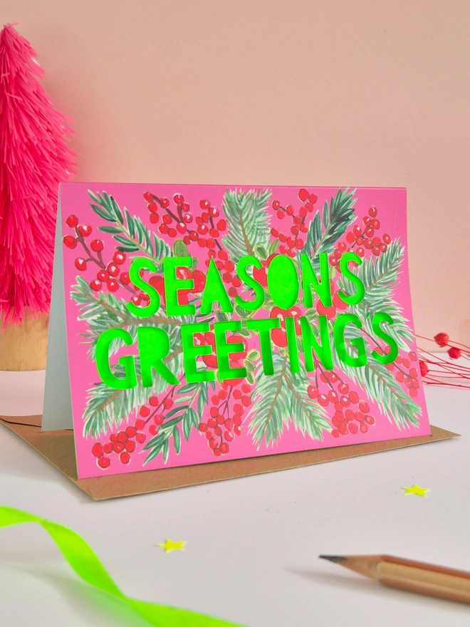 Cranberry design Christmas Card with Seasons greetings in paper cut text and a neon green backing paper 