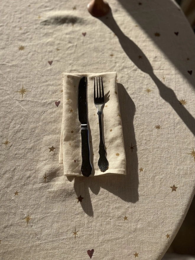 Celestial Linen Dinner Napkins (Set Of 2), a linen napkin with a sun motif sitting on a plain white surface. 