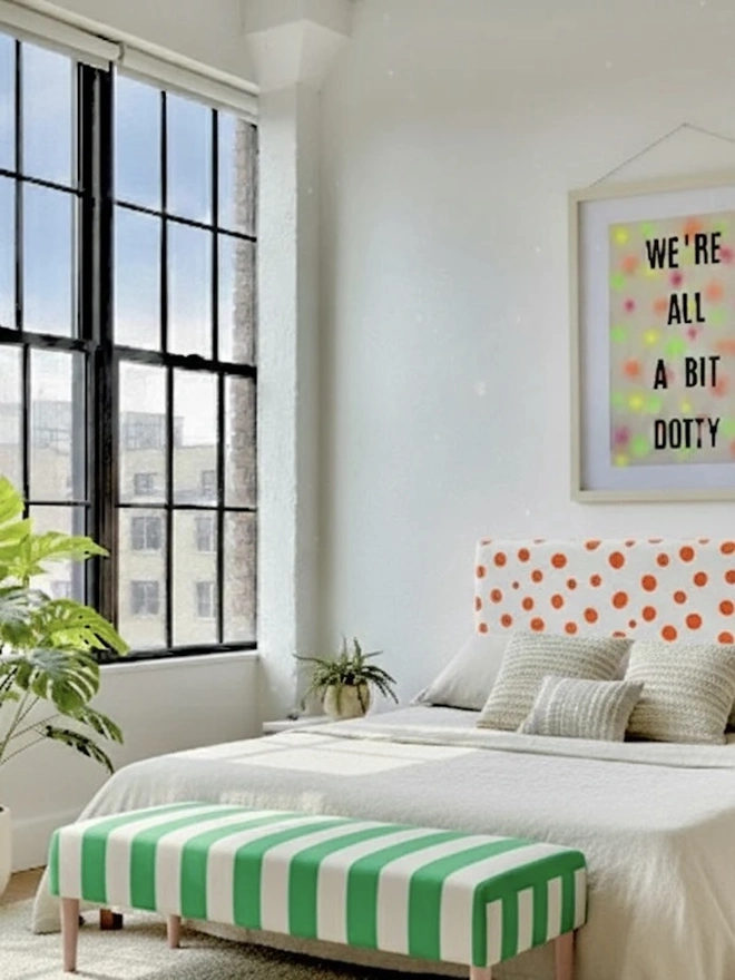 Hand Painted Upholstered Striped Linen Coffee Table Ottoman, neon green striped coffee table in a bedroom against a white bed. 