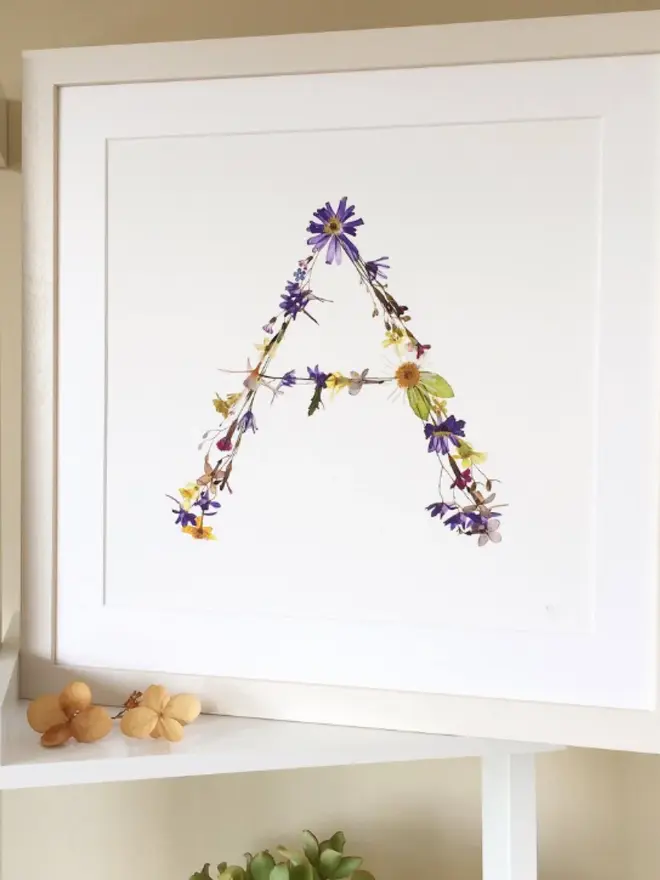Pressed Wildflower Letter Print, a wildflower alphabet letter print sitting framed. 