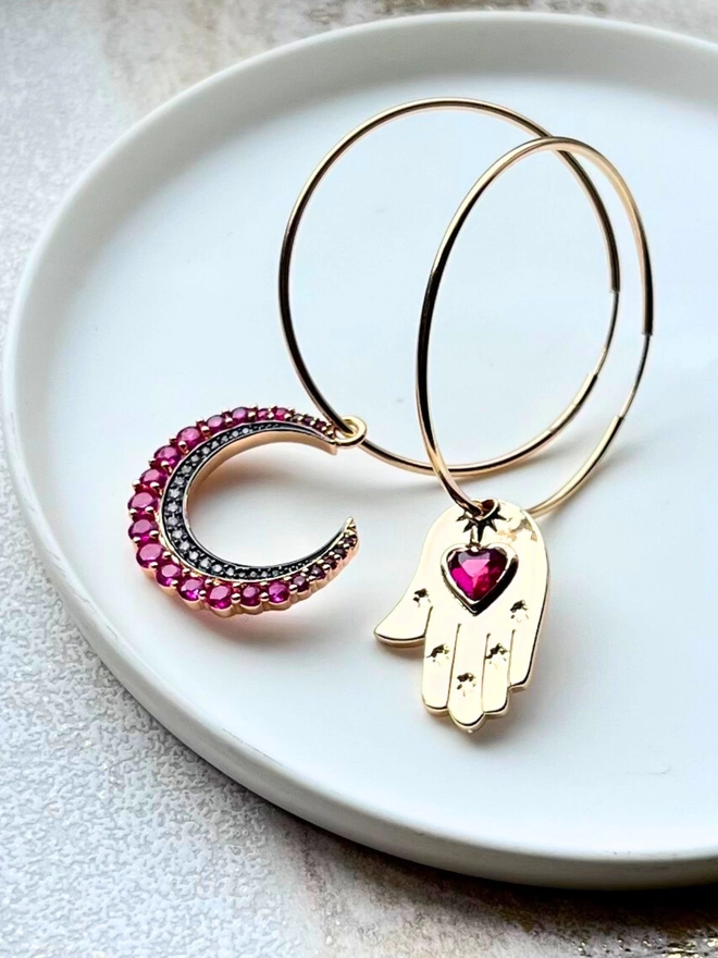 Large gold hoops with hamsa hand and pink crescent moon charms