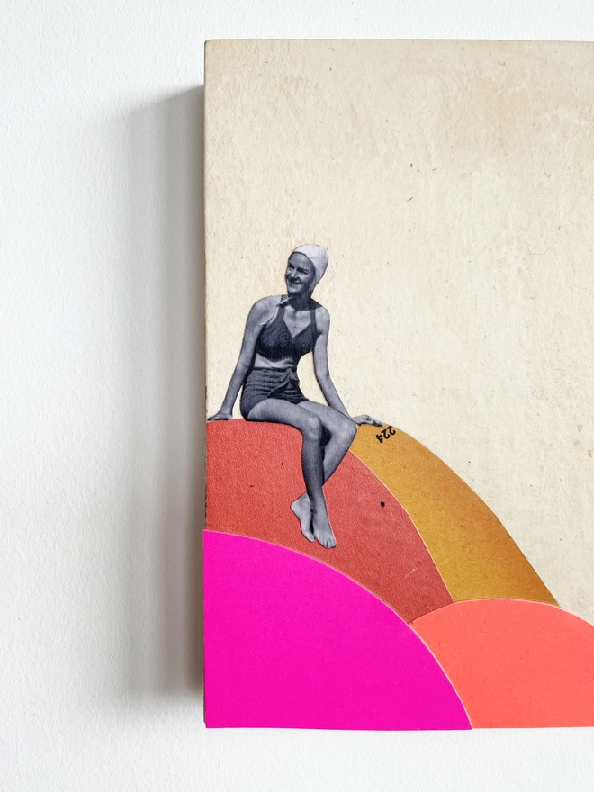 A brightly coloured artwork made with a mix of neon pink and orange card and vintage papers. It is a female portrait of a swimmer who is about to dive off the colourful rocks into the sea.