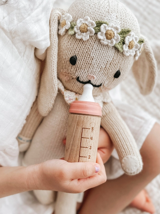 Wooden toy bottle in salmon with knitted rabbit doll