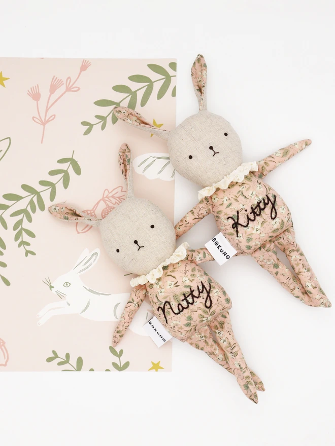 Handmade easter bunny doll with natural linen, floral pink cotton outfit and broderie anglaide lace frill collar, with personalised name embroidery on their body.