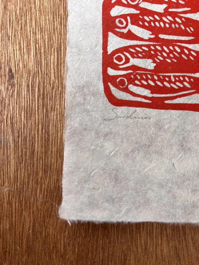 Hand printed sardine lino print featuring detailed sardines arranged in a bold folk-inspired design, printed on natural paper.
