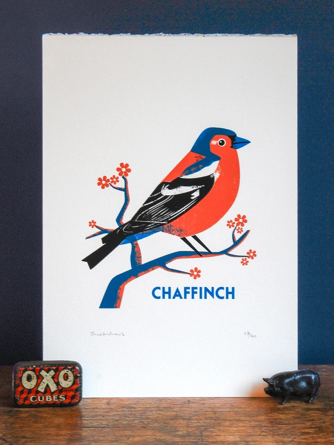 A screenprint of a Chaffinch bird on white paper against a navy blue background.