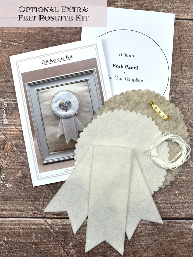 The rosette kit contents, showing instruction sheet, pattern piece, white & beige felt pieces, white yarn & gilt brooch.