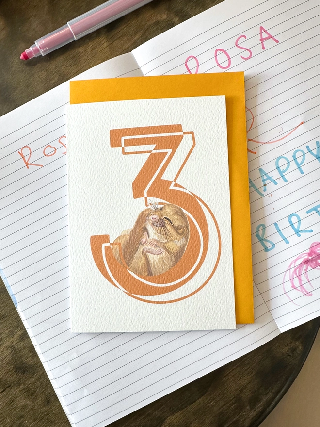 a white card with a big orange number 3 and an illustrated dormouse with a bright yellow envelope