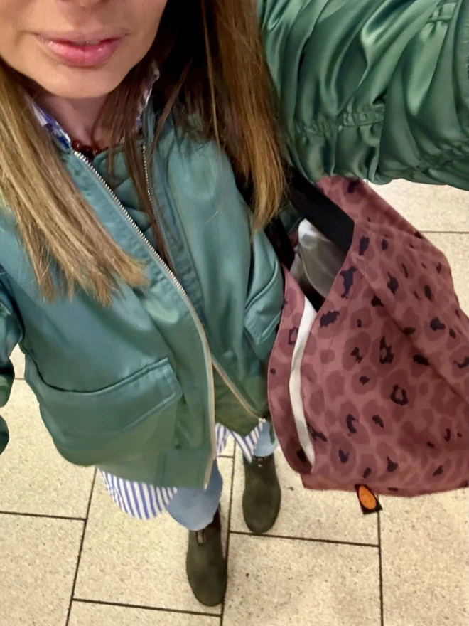 Mocha Contents bag on woman with green bomber jacket