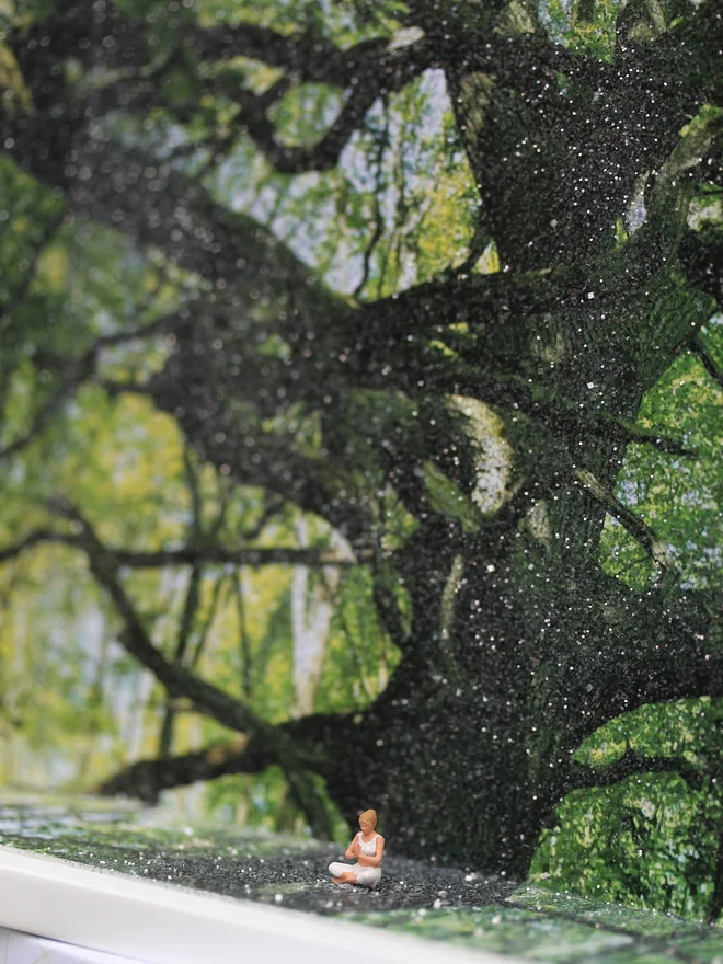 Miniature scene in an artbox showing a tiny woman 'meditating against a sparkling forested backdrop. 