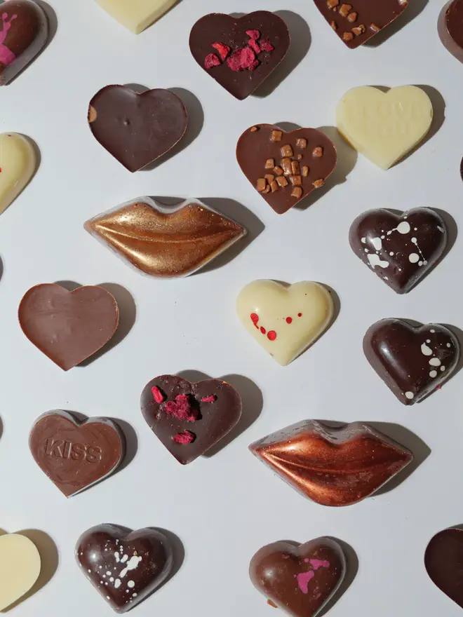 A range of chocolates heart cube scattered on a white table. 