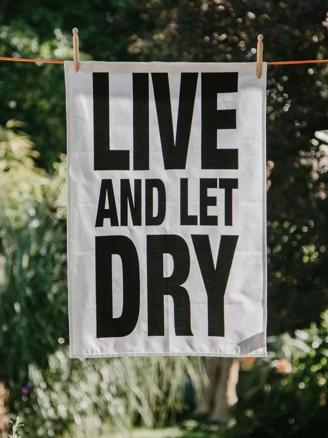 London Drying Live And Let Dry tea towel on a clothes line.