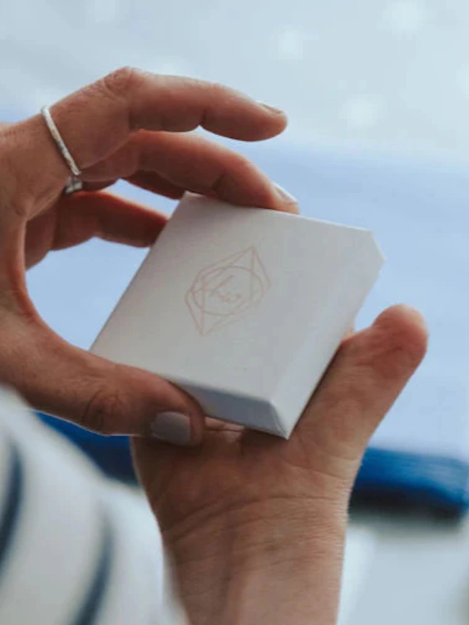 A woman holding open the gift box