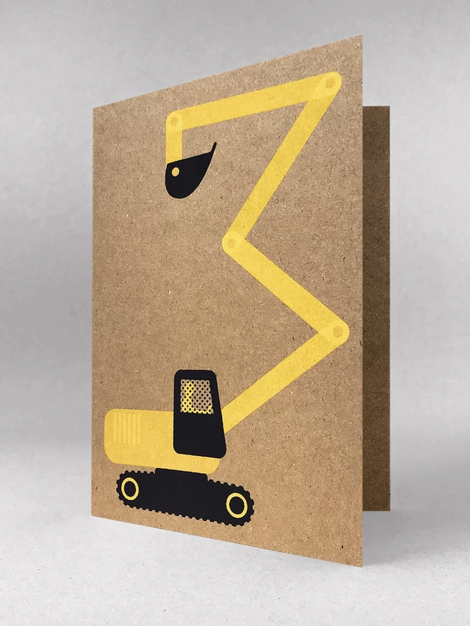 A brown kraft greetings card with a yellow and black digger stood in a light grey studio shot, soft shadows. The digger has been screenprinted in two colours and the arm of the digger makes a number 3.
