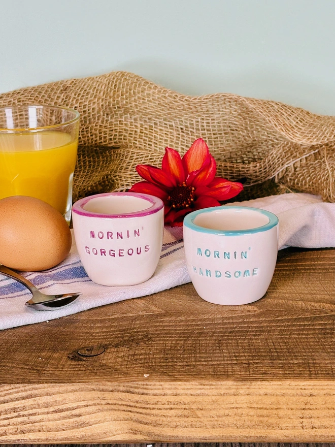 Pair of handmade ceramic egg cups with the lettering Mornin Handsome and Mornin Gorgeous