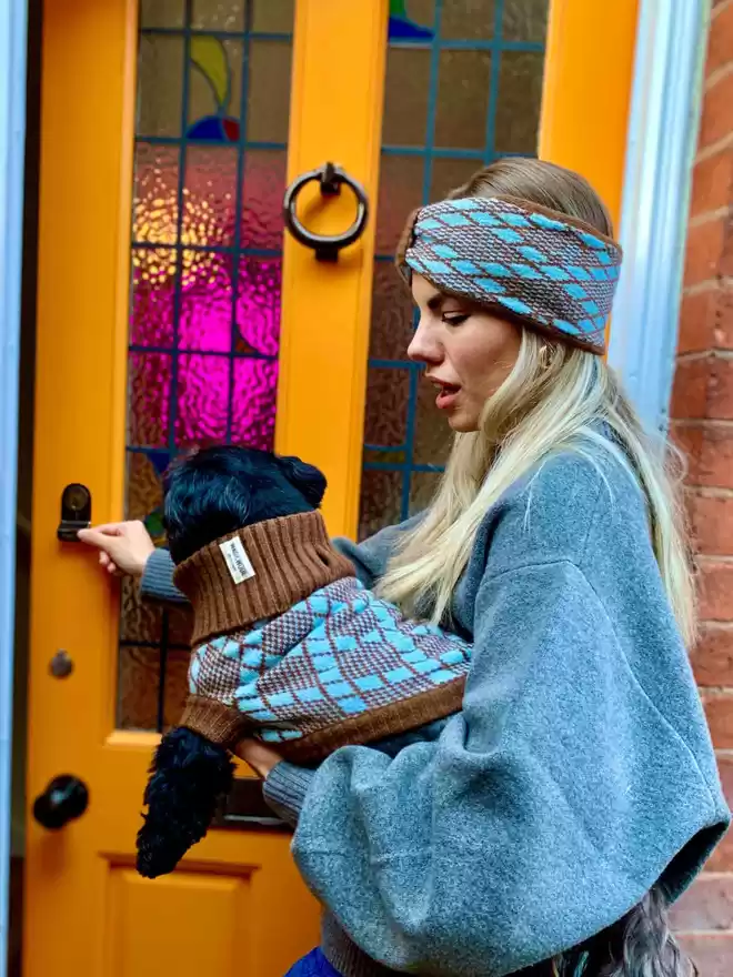 lady in a turquoise headband and a dog in a matching jumper
