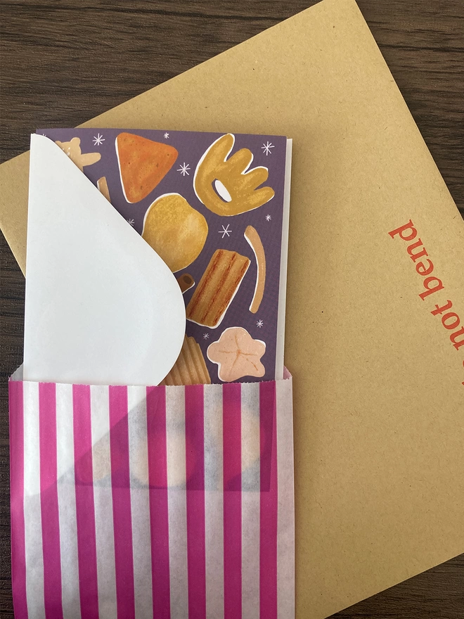 Crisps card packed with a white envelope inside a paper bag