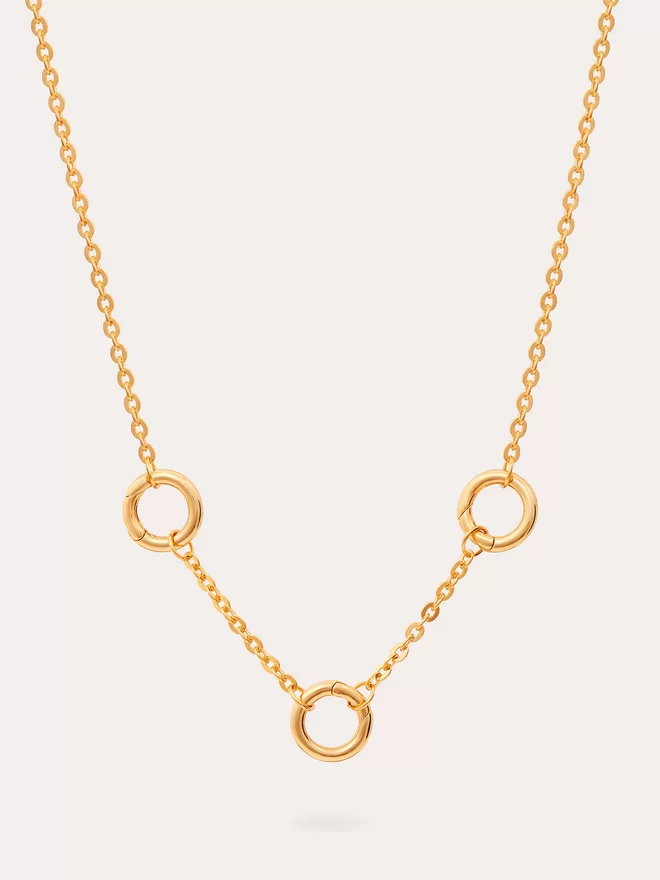 still life image of a triple link cable chain gold necklace