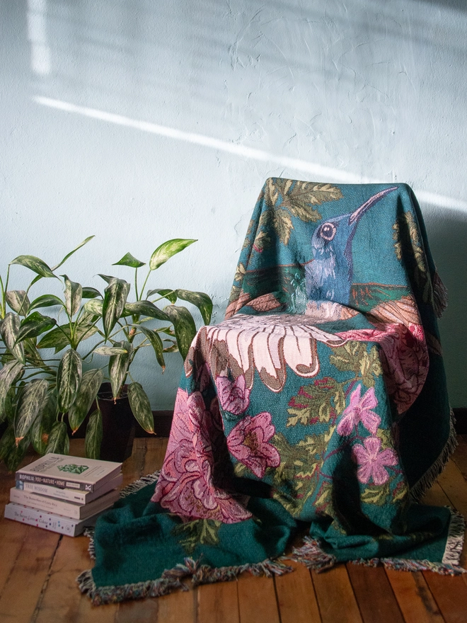 Joy Hummingbird Woven Blanket on chair