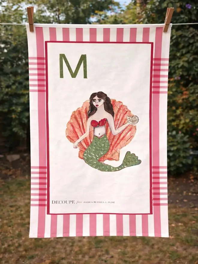 a-z alphabet tea towel. a tea towel with a mermaid print and the letter 'm' in the corner.