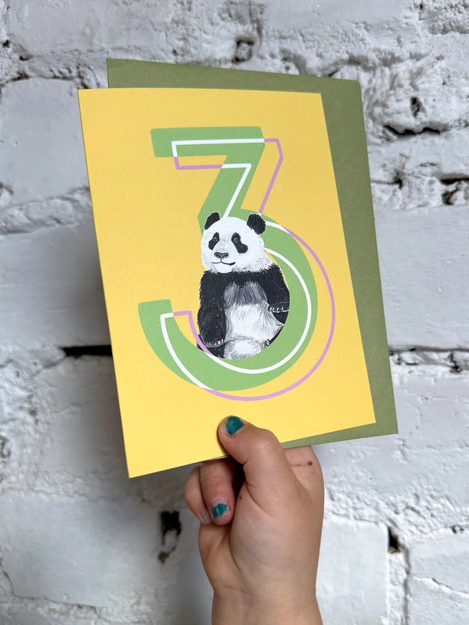 a bright yellow card with a big green number 3 and an illustrated panda with a green envelope